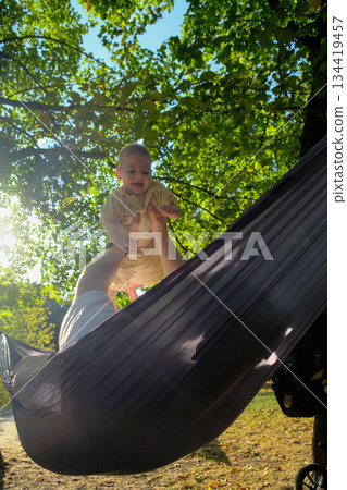 Parent and Baby Enjoying Hammock Time Outdoors 134419457