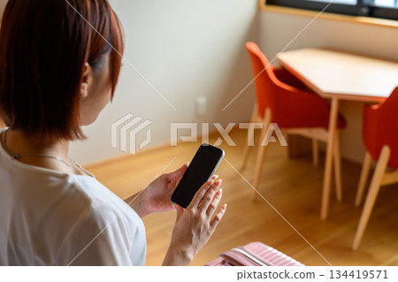 女子在飯店房間看著智慧型手機 134419571