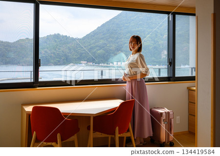 一位女士站在飯店房間裡，欣賞著壯麗的景色。 134419584