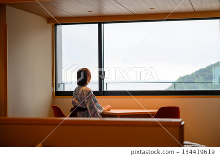 一位身穿浴衣的女子正倚窗向外望去。 134419619