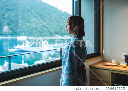 一位身穿浴衣的女子在窗邊眺望大海。 134419625