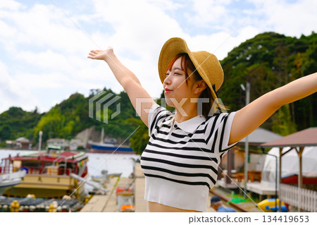 一位張開雙臂的女子和港口景色 134419653