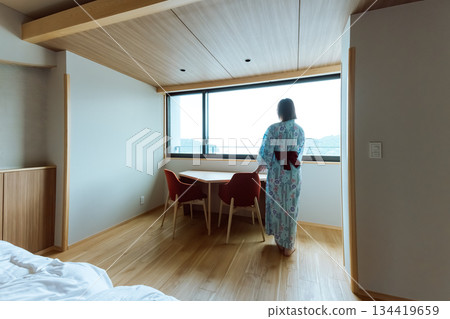 A woman looking out the window in a modern Japanese room A woman looking out the window in a modern Japanese room 134419659