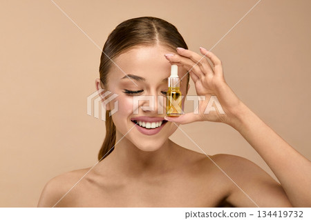 Beauty woman holding serum for skincare in studio background focused on healthy face and glow treatment Beauty woman holding serum for skincare in studio background focused on healthy face and glow treatment 134419732