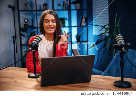 Woman is hosting radio podcast with microphone and laptop 134419904