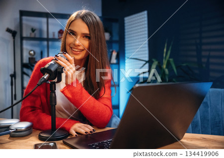 Woman is hosting radio podcast with microphone and laptop Woman is hosting radio podcast with microphone and laptop 134419906
