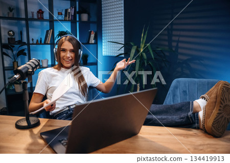 Woman is hosting radio podcast with microphone and laptop 134419913