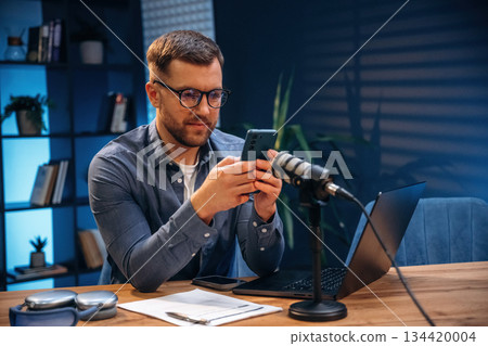 Trading expert is analyzing data. Man with microphone in the studio, conception of podcast 134420004