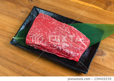 Beef shoulder block Raw meat ingredients photo Black dish and wood grain table 134420159