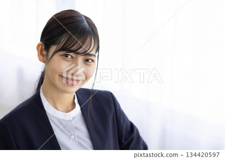 Young businesswoman smiling by the window Young businesswoman smiling by the window 134420597