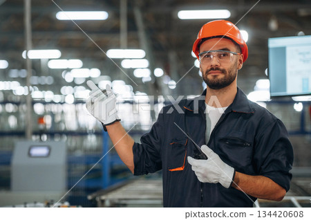 Copy space, showing by the hand. Man is working in the modern factory Copy space, showing by the hand. Man is working in the modern factory 134420608