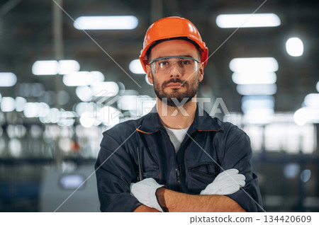 Standing with arms crossed. Man is working in the modern factory Standing with arms crossed. Man is working in the modern factory 134420609