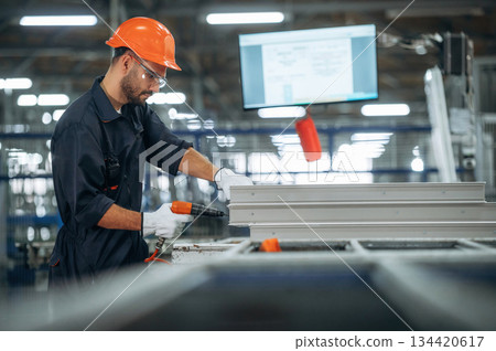 Using screwdriver. Man is working in the modern factory Using screwdriver. Man is working in the modern factory 134420617