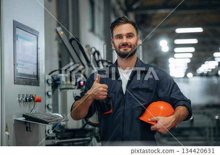 In protective hard hat. Man is working in the modern factory 134420631