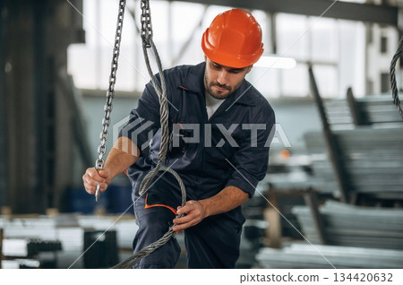 Works with cables. Man is in the modern factory Works with cables. Man is in the modern factory 134420632
