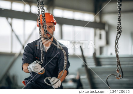 Works with cables. Man is in the modern factory Works with cables. Man is in the modern factory 134420635