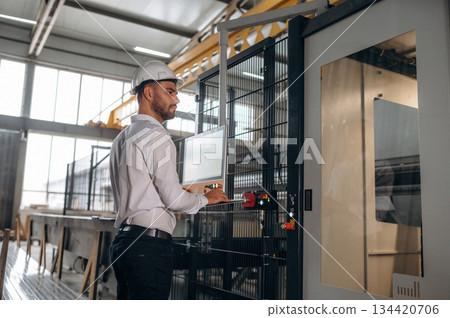 Manager is in white shirt. Man is working in the modern factory Manager is in white shirt. Man is working in the modern factory 134420706