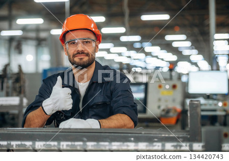 Showing thumb up. Man is working in the modern factory Showing thumb up. Man is working in the modern factory 134420743