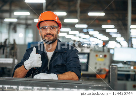 Showing thumb up. Man is working in the modern factory Showing thumb up. Man is working in the modern factory 134420744