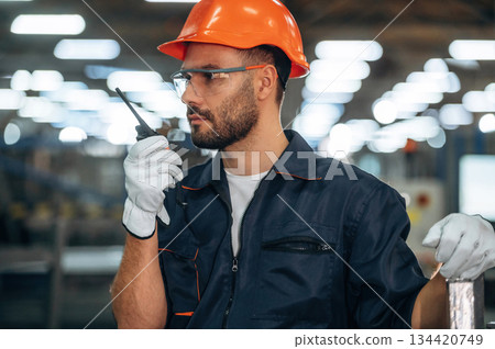 Communication by the radio, walkie talkie. Man is working in the modern factory 134420749
