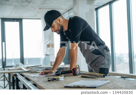 Writing on the paper. A man is renovating an unfinished room Writing on the paper. A man is renovating an unfinished room 134420830