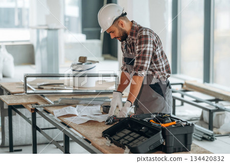 Writing on the paper. A man is renovating an unfinished room 134420832