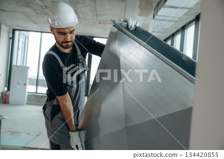 Moving stuff. A man is renovating an unfinished room 134420855