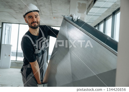 Moving stuff. A man is renovating an unfinished room 134420856