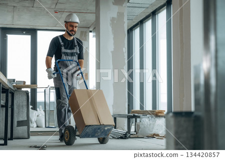 Moving stuff. A man is renovating an unfinished room 134420857
