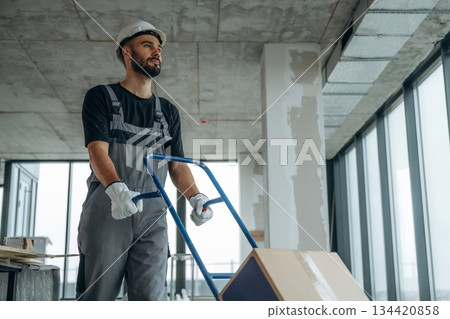 Moving stuff. A man is renovating an unfinished room 134420858