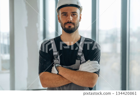Arms crossed, standing. A man is renovating an unfinished room Arms crossed, standing. A man is renovating an unfinished room 134420861