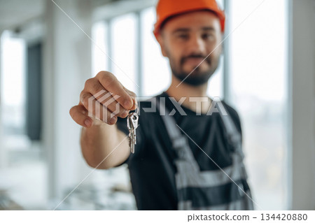 Buy it. Happy construction worker is holding keys for new home 134420880