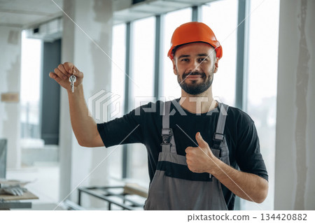 Buy it. Happy construction worker is holding keys for new home 134420882