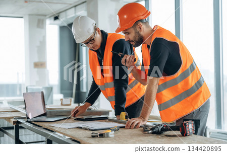In the unfinished room together. Two construction workers In the unfinished room together. Two construction workers 134420895