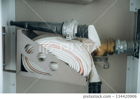 Fire hose is against the wall, ready to use Fire hose is against the wall, ready to use 134420906