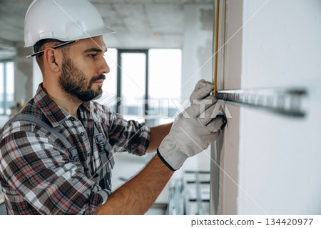 A man is renovating an unfinished room 134420977