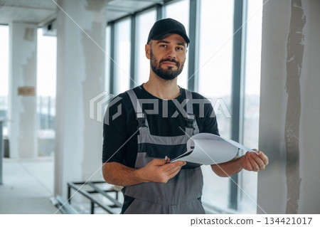 Notepad is in hands. A man is renovating an unfinished room Notepad is in hands. A man is renovating an unfinished room 134421017
