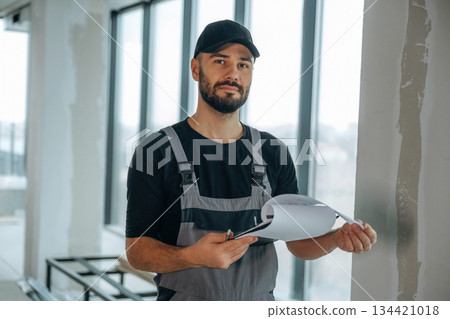 Notepad is in hands. A man is renovating an unfinished room Notepad is in hands. A man is renovating an unfinished room 134421018