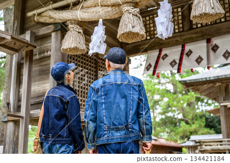 一對身著牛仔服的老夫婦正在參拜神社 134421184