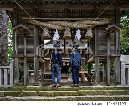 Two people praying at a shrine Two people praying at a shrine 134421195