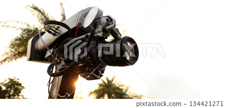 Behind the scenes of movie shooting or video production and film crew team with camera equipment at outdoor location. Video camera with professional robotic arm. BTS of Filming camera setup at outdoor 134421271