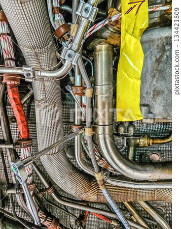 Detailed close-up of aircraft engine compartment with hydraulic pipes, cables and connectors. Aviation engineering and technical maintenance concept. High quality photo 134421809