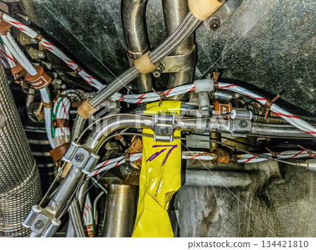 Detailed close-up of aircraft engine compartment with hydraulic pipes, cables and connectors. Aviation engineering and technical maintenance concept. High quality photo 134421810