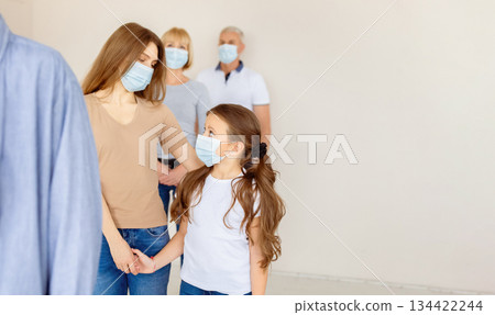 Young mother and her cute daughter in face masks waiting in queue for coronavirus immunization at hospital. Covid-19 vaccination, prevention of global virus spread concept Young mother and her cute daughter in face masks waiting in queue for coronavirus immunization at hospital. Covid-19 vaccination, prevention of global virus spread concept 134422244