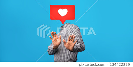 A person wearing a checkered shirt holds both hands up as if expressing hesitation. Above their head is a heart-shaped symbol, representing social media engagement. A person wearing a checkered shirt holds both hands up as if expressing hesitation. Above their head is a heart-shaped symbol, representing social media engagement. 134422259