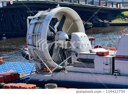 Airboat prepares for water navigation near a busy bridge at midday Airboat prepares for water navigation near a busy bridge at midday 134422734