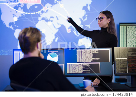 Cybersecurity analysts collaboratively investigating threats in a high-tech monitoring center Cybersecurity analysts collaboratively investigating threats in a high-tech monitoring center 134423814