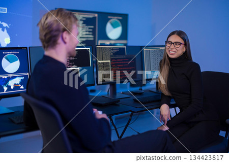 Collaborative incident response team discussing cybersecurity data in a digital control room Collaborative incident response team discussing cybersecurity data in a digital control room 134423817