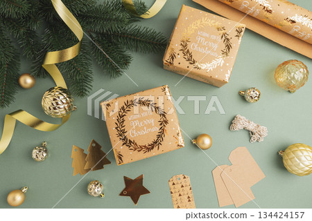 Christmas Gift Wrapping Flatlay with Ornaments and Tags on Green Background Christmas Gift Wrapping Flatlay with Ornaments and Tags on Green Background 134424157