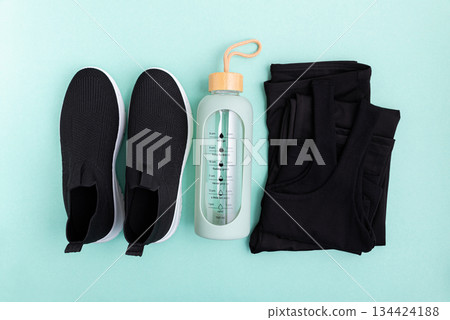 Fitness apparel and accessories laid out on a blue background. 134424188